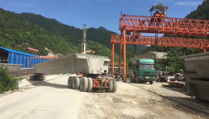 Gantry crane loading precast beam onto transport truck